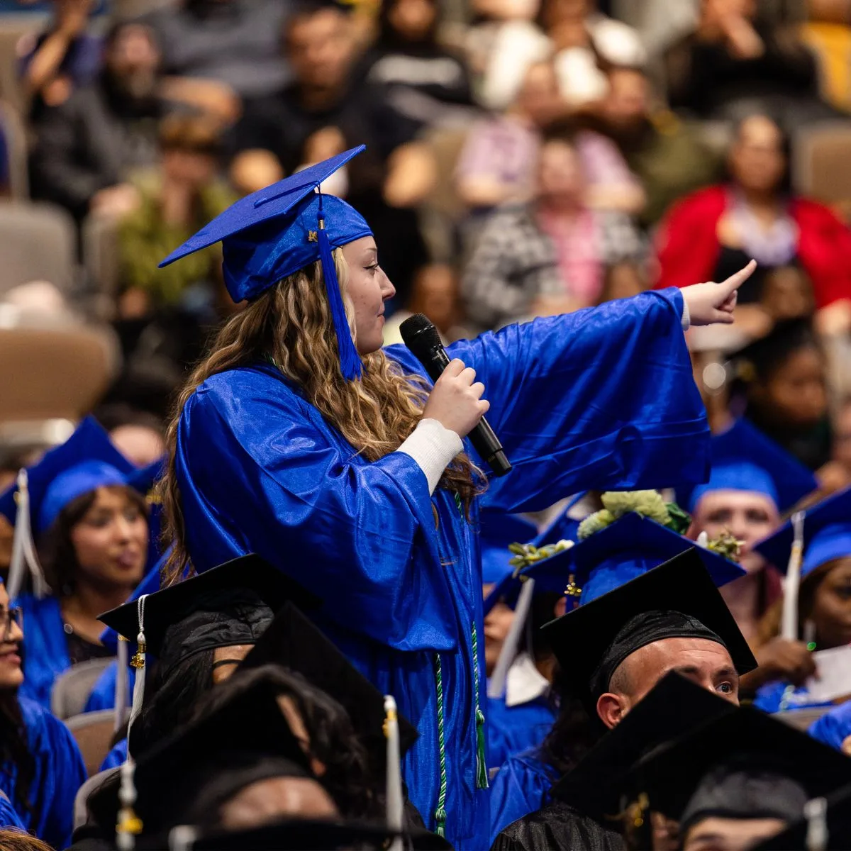 HS Grad pointing and thanking those that supported her on the way to earning her diploma.